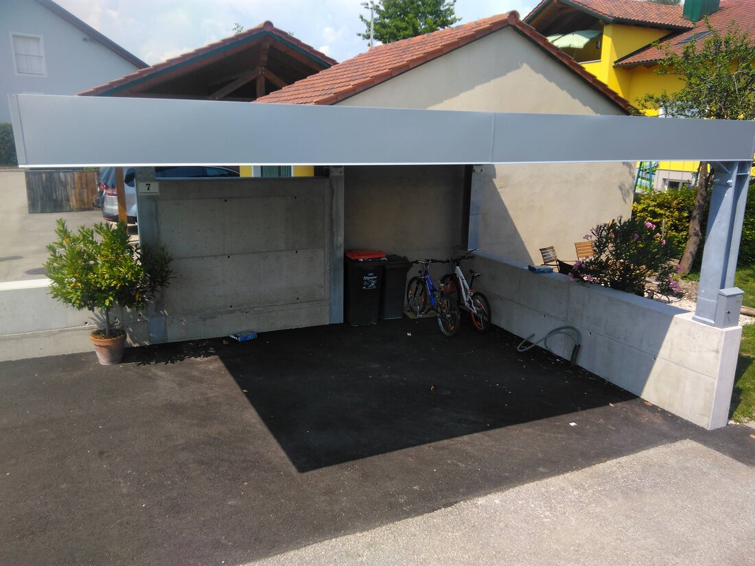 Ein Carport mit Stahl-I-Trägerkonstruktion, an einer Ecke ohne Säule um ein leichtes einparken zu ermöglichen.
