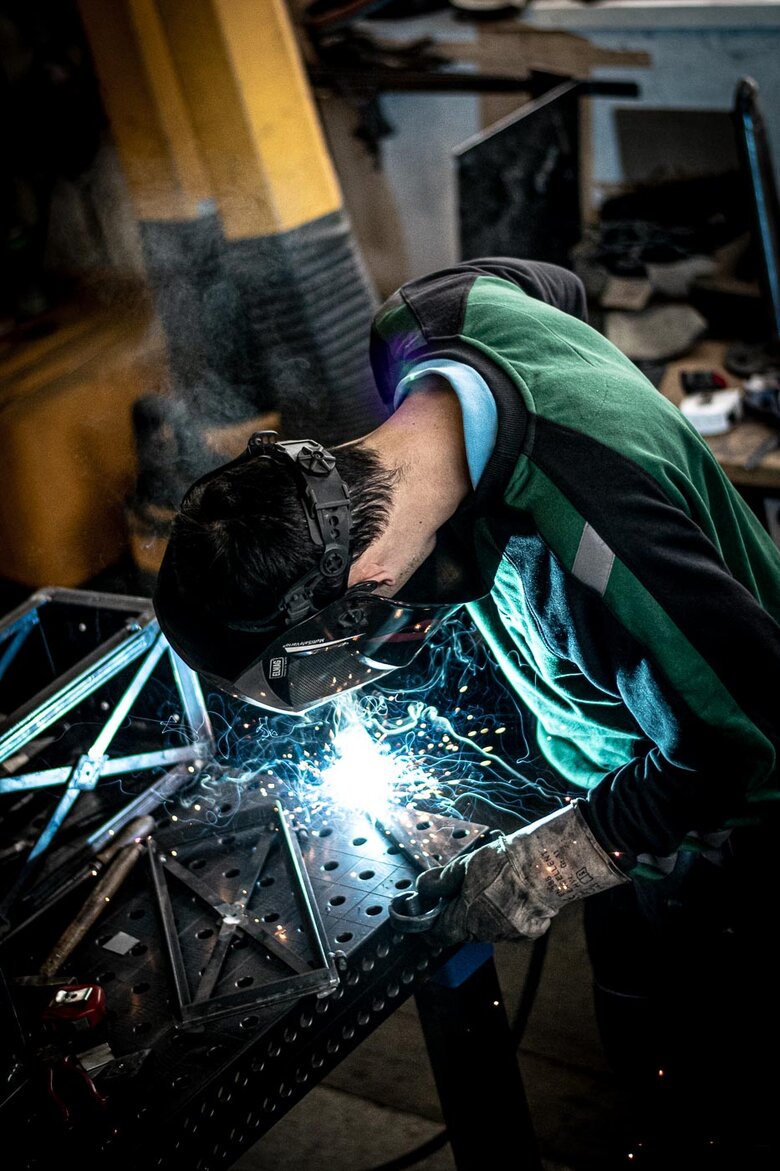 Metall-Arbeiter schweißt eine Laterne aus Metall zusammen