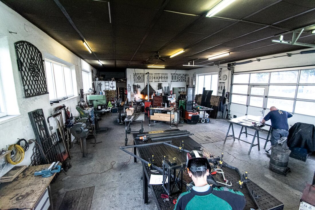 Totalansicht über die Metallwerkstatt der Firma Schöndorfer mit zwei Arbeitern und vielen Geräten